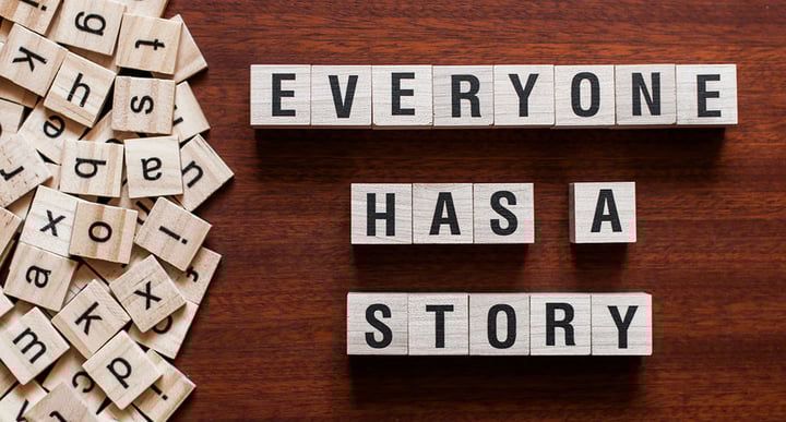 Scrabble pieces spelling out "Everyone has a story"